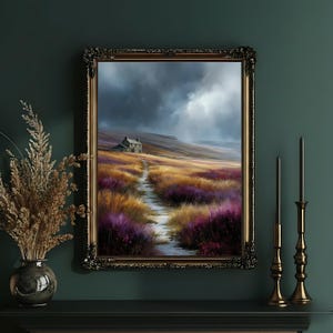 May include: A framed landscape painting depicts a path leading to a small house on a hill under a stormy sky. The path winds through fields of purple and gold flowers. The ornate gold frame adds a touch of elegance to the artwork.