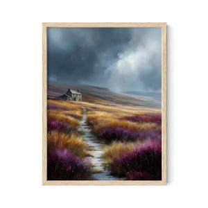 May include: A framed landscape print depicts a stone cottage on a hillside. A path leads through fields of purple and gold wildflowers under a dramatic, cloudy sky. The artwork is set in a light-colored wooden frame.