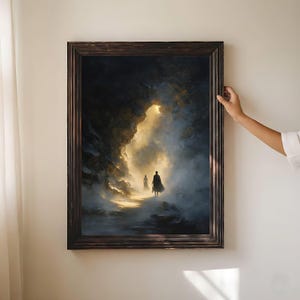 May include: A framed artwork depicting two figures walking towards a bright light in a dark, atmospheric landscape. The painting features a dramatic contrast of dark blues and golds, with a textured, painterly style. The frame is a dark, ornate wood.