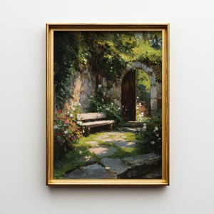 May include: A framed painting depicts a serene garden scene. A wooden bench sits beneath a stone wall covered in greenery and flowers. An arched doorway leads to a sunlit area. The artwork is framed in a gold-colored frame.