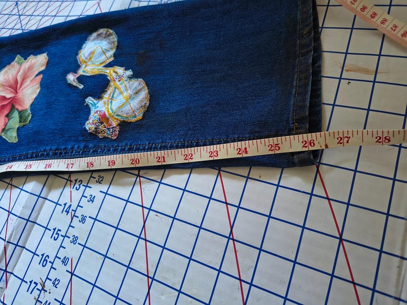 Patchwork Boho AppliquePatched Upcycled Cropped DarkerDenim Cuffed or Straight Jeans SIZE 14 TO 16 Stretch VintageStyledenim.   Inseam 26.  Vintage-look handpainted throughout Flowers, Birds, Cat, and appliques of various designs.  Handmade and handcrafted.   Unique Applique Jeans Distressed.  Highrise High Waisted, Handpainted Handmade Appliqued Straight Style Jeans. Size 14 to 16 depending on your measurements.  Check the measurements.  Handmade Boho Sash Bohemian design crocheted with bells.