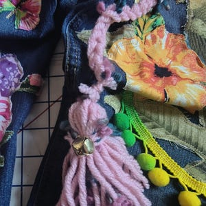 Patchwork Boho AppliquePatched Upcycled Cropped DarkerDenim Cuffed or Straight Jeans SIZE 14 TO 16 Stretch VintageStyledenim.   Inseam 26.  Vintage-look handpainted throughout Flowers, Birds, Cat, and appliques of various designs.  Handmade and handcrafted.   Unique Applique Jeans Distressed.  Highrise High Waisted, Handpainted Handmade Appliqued Straight Style Jeans. Size 14 to 16 depending on your measurements.  Check the measurements.  Handmade Boho Sash Bohemian design crocheted with bells.