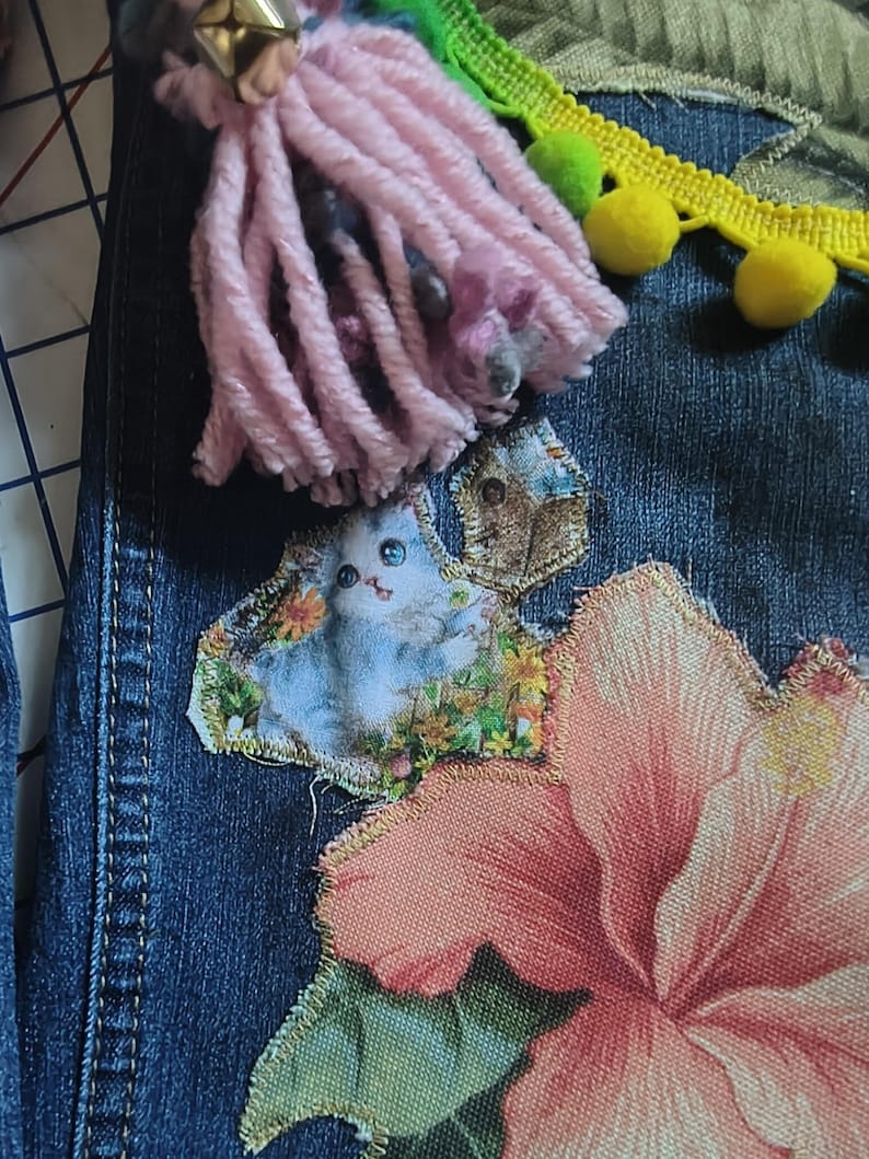 Patchwork Boho AppliquePatched Upcycled Cropped DarkerDenim Cuffed or Straight Jeans SIZE 14 TO 16 Stretch VintageStyledenim.   Inseam 26.  Vintage-look handpainted throughout Flowers, Birds, Cat, and appliques of various designs.  Handmade and handcrafted.   Unique Applique Jeans Distressed.  Highrise High Waisted, Handpainted Handmade Appliqued Straight Style Jeans. Size 14 to 16 depending on your measurements.  Check the measurements.  Handmade Boho Sash Bohemian design crocheted with bells.