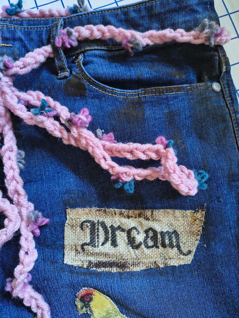 Patchwork Boho AppliquePatched Upcycled Cropped DarkerDenim Cuffed or Straight Jeans SIZE 14 TO 16 Stretch VintageStyledenim.   Inseam 26.  Vintage-look handpainted throughout Flowers, Birds, Cat, and appliques of various designs.  Handmade and handcrafted.   Unique Applique Jeans Distressed.  Highrise High Waisted, Handpainted Handmade Appliqued Straight Style Jeans. Size 14 to 16 depending on your measurements.  Check the measurements.  Handmade Boho Sash Bohemian design crocheted with bells.