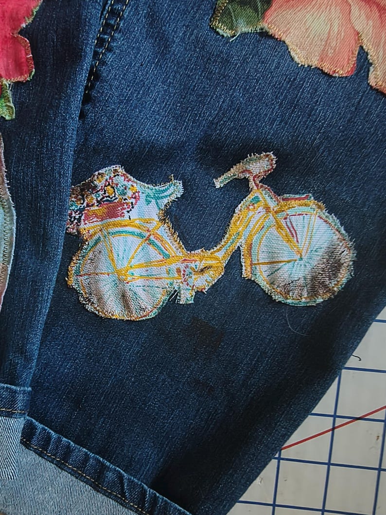 Patchwork Boho AppliquePatched Upcycled Cropped DarkerDenim Cuffed or Straight Jeans SIZE 14 TO 16 Stretch VintageStyledenim.   Inseam 26.  Vintage-look handpainted throughout Flowers, Birds, Cat, and appliques of various designs.  Handmade and handcrafted.   Unique Applique Jeans Distressed.  Highrise High Waisted, Handpainted Handmade Appliqued Straight Style Jeans. Size 14 to 16 depending on your measurements.  Check the measurements.  Handmade Boho Sash Bohemian design crocheted with bells.