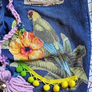 Patchwork Boho AppliquePatched Upcycled Cropped DarkerDenim Cuffed or Straight Jeans SIZE 14 TO 16 Stretch VintageStyledenim.   Inseam 26.  Vintage-look handpainted throughout Flowers, Birds, Cat, and appliques of various designs.  Handmade and handcrafted.   Unique Applique Jeans Distressed.  Highrise High Waisted, Handpainted Handmade Appliqued Straight Style Jeans. Size 14 to 16 depending on your measurements.  Check the measurements.  Handmade Boho Sash Bohemian design crocheted with bells.