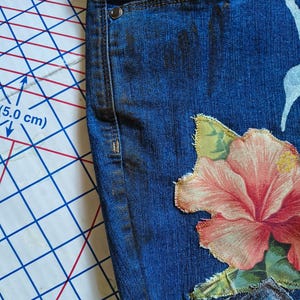 Patchwork Boho AppliquePatched Upcycled Cropped DarkerDenim Cuffed or Straight Jeans SIZE 14 TO 16 Stretch VintageStyledenim.   Inseam 26.  Vintage-look handpainted throughout Flowers, Birds, Cat, and appliques of various designs.  Handmade and handcrafted.   Unique Applique Jeans Distressed.  Highrise High Waisted, Handpainted Handmade Appliqued Straight Style Jeans. Size 14 to 16 depending on your measurements.  Check the measurements.  Handmade Boho Sash Bohemian design crocheted with bells.