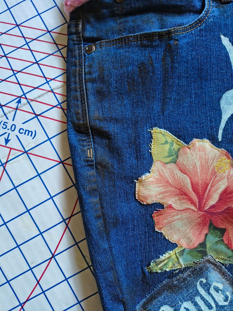 Patchwork Boho AppliquePatched Upcycled Cropped DarkerDenim Cuffed or Straight Jeans SIZE 14 TO 16 Stretch VintageStyledenim.   Inseam 26.  Vintage-look handpainted throughout Flowers, Birds, Cat, and appliques of various designs.  Handmade and handcrafted.   Unique Applique Jeans Distressed.  Highrise High Waisted, Handpainted Handmade Appliqued Straight Style Jeans. Size 14 to 16 depending on your measurements.  Check the measurements.  Handmade Boho Sash Bohemian design crocheted with bells.