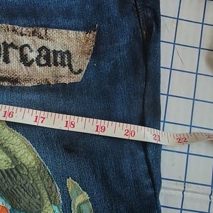 Patchwork Boho AppliquePatched Upcycled Cropped DarkerDenim Cuffed or Straight Jeans SIZE 14 TO 16 Stretch VintageStyledenim.   Inseam 26.  Vintage-look handpainted throughout Flowers, Birds, Cat, and appliques of various designs.  Handmade and handcrafted.   Unique Applique Jeans Distressed.  Highrise High Waisted, Handpainted Handmade Appliqued Straight Style Jeans. Size 14 to 16 depending on your measurements.  Check the measurements.  Handmade Boho Sash Bohemian design crocheted with bells.
