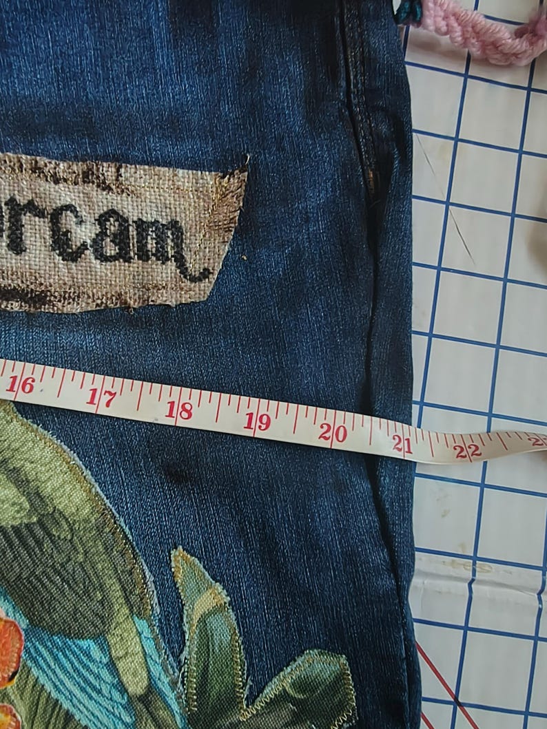 Patchwork Boho AppliquePatched Upcycled Cropped DarkerDenim Cuffed or Straight Jeans SIZE 14 TO 16 Stretch VintageStyledenim.   Inseam 26.  Vintage-look handpainted throughout Flowers, Birds, Cat, and appliques of various designs.  Handmade and handcrafted.   Unique Applique Jeans Distressed.  Highrise High Waisted, Handpainted Handmade Appliqued Straight Style Jeans. Size 14 to 16 depending on your measurements.  Check the measurements.  Handmade Boho Sash Bohemian design crocheted with bells.