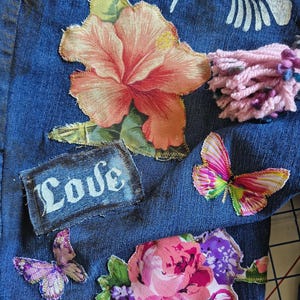 Patchwork Boho AppliquePatched Upcycled Cropped DarkerDenim Cuffed or Straight Jeans SIZE 14 TO 16 Stretch VintageStyledenim.   Inseam 26.  Vintage-look handpainted throughout Flowers, Birds, Cat, and appliques of various designs.  Handmade and handcrafted.   Unique Applique Jeans Distressed.  Highrise High Waisted, Handpainted Handmade Appliqued Straight Style Jeans. Size 14 to 16 depending on your measurements.  Check the measurements.  Handmade Boho Sash Bohemian design crocheted with bells.
