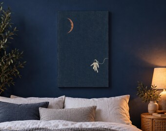 May include: A rectangular wall art print featuring a dark navy blue background with a small, white astronaut floating in the lower right quadrant and a thin, curved orange crescent moon positioned in the upper left corner of the composition.
