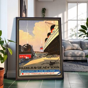 May include: Framed vintage travel poster featuring a train and a large ocean liner docked at a pier. The poster has the text "PARIS.HAVRE.NEW YORK" and "CHEMINS DE FER DE L'ÉTAT" and "C.G. TRANSATLANTIQUE."