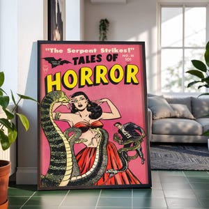 May include: Framed vintage comic book cover titled "Tales of Horror" with a pink background. The artwork features a woman in a red dress with snakes, and a man in a suit. The text "The Serpent Strikes!" and "HORROR" are prominent.