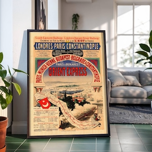 May include: Framed vintage travel poster for the Orient Express train, featuring a map and route details. The poster has a black frame and displays text in French and English, with a color palette of red, blue, and beige. The poster's route includes London, Paris, and Constantinople.