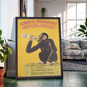 May include: Framed vintage advertisement featuring a chimpanzee drinking from a bottle. The poster has a yellow background with red and white text, and the chimpanzee is sitting on a wooden crate. The poster is in a black frame.
