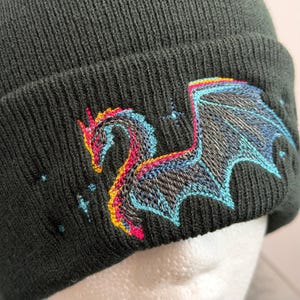 Unique Gift Beanie Dragon Embroidery Winter Hat Black Knit Cap Fantasy Design Mythical Creature Headwear Warm Fleece Lined Acrylic Material Unisex Fit Special Present Idea Cold Weather Accessory Blue Pink Thread Detail Gothic Style Element