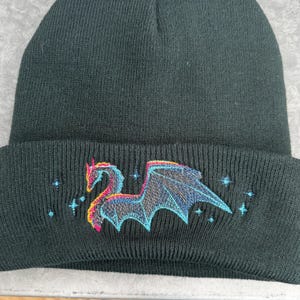 Fleece Lined Beanie Dragon Design Winter Hat Black Knit Material Soft Comfortable Headwear Embroidered Mythical Creature Warm Acrylic Cap Unisex Fit Cold Weather Protection Fantasy Inspired Accessory Gothic Style Element Blue Pink Thread
