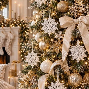 May include: A Christmas tree decorated with white lace snowflake ornaments, gold and white baubles, and a large beige velvet ribbon. The tree features warm string lights, gold leaf accents, and small white berry sprays throughout the branches.