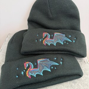 Dragon Winter Beanie Black Knit Hat Embroidered Design Mythical Creature Gothic Style Warm Headwear Fleece Lined Acrylic Material Unisex Fit Cold Weather Protection Fantasy Enthusiast Gift Blue Pink Embroidery Unique Pattern Stylish Look