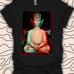 May include: A black t-shirt featuring a graphic print of a person meditating with a hand over their face. The hand has a 3D effect and is in a red and green colour scheme.