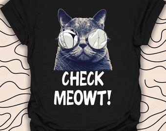 Puede incluir: Camiseta negra con un gato gris que lleva gafas de sol espejadas y el texto "CHECK MEOWT!"
