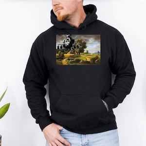 May include: Black hooded sweatshirt featuring a printed image of a helicopter over a landscape. The image on the sweatshirt depicts a helicopter in flight over a field with trees and a house. The sweatshirt has a front pocket and a drawstring hood.
