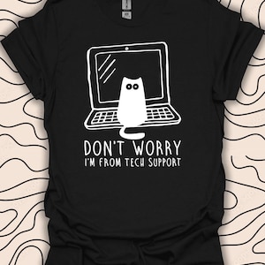 May include: Black t-shirt featuring a white graphic of a cat peeking out of a laptop screen. The text "Don't worry I'm from tech support" is below the image.