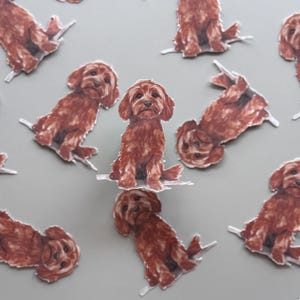 May include: A collection of brown dog stickers on a gray background. The stickers depict a seated dog with a fluffy coat. The stickers are cut out and have a white border. The dogs are facing different directions.