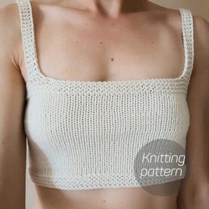 May include: A white knitted crop top with thin straps. The top has a square neckline and a ribbed texture. The text "Knitting pattern" is visible in the lower right corner of the image.