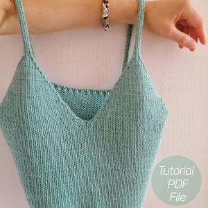 Op de afbeelding: Een lichtgroen gebreid tanktop met dunne bandjes. Het topje heeft een V-hals en is gecropped. De tekst "Tutorial PDF File" is zichtbaar in de rechterbenedenhoek van de afbeelding.