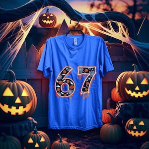 May include: A blue t-shirt with the number "67" in orange, decorated with spiderwebs and jack-o'-lanterns. The shirt is hanging on a black hanger, with carved pumpkins and a spooky Halloween scene in the background.