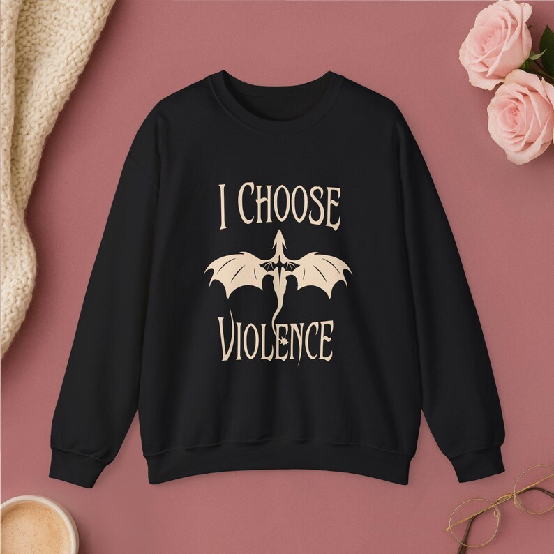 Comfortable white crewneck sweatshirt. Striking graphic design on the front features a majestic Black Dragon, boldly proclaiming the phrase I Chose Violence a statement that's sure to resonate with fans of intense, passionate relationships.