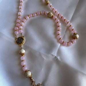 Rosenkranz in Blassrosa und Holz.