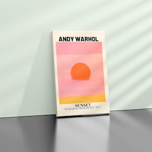 Op de afbeelding: Een print van Andy Warhols schilderij "Sunset", met een grote oranje zon tegen een roze en gele achtergrond. De tekst "SUNSET" staat onder de afbeelding, samen met "MUSEUM OF MODERN ART 1972".
