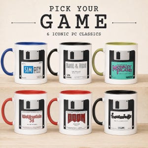 May include: Six white ceramic mugs featuring floppy disk designs with labels for Sim City Classic, Alone in the Dark, The Secret of Monkey Island, Wolfenstein 3D, Doom, and Lemmings. Each mug has a colored handle and interior rim in blue, black, green, or red.