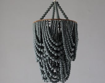 May include: A grey beaded chandelier with a wooden frame. The beads are arranged in a cascading pattern, creating a unique and modern look.