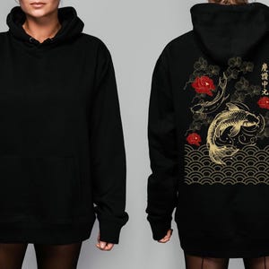 May include: Black hoodie with a gold and red Japanese-inspired design featuring koi fish, flowers, and waves. The text on the back reads "意欲の中に", which translates to "Within ambition".