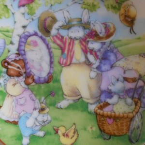 Pode incluir: Uma ilustra&ccedil;&atilde;o colorida de um grupo de animais, incluindo um texugo, um coelho e um pintinho, usando chap&eacute;us e curtindo um dia ao ar livre. Os animais s&atilde;o retratados em um estilo caprichoso com cores brilhantes e detalhes intrincados. A cena se passa em um campo gramado com uma &aacute;rvore e uma cesta.