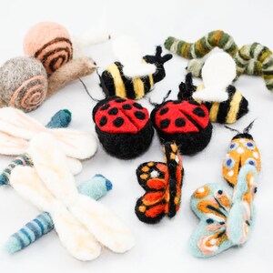 Pu&ograve; includere: Una collezione di figurine di animali in feltro, tra cui una lumaca, due coccinelle, due farfalle, due api, un bruco e due libellule. Le figurine sono tutte colorate in modo vivace e presentano dettagli intricati.