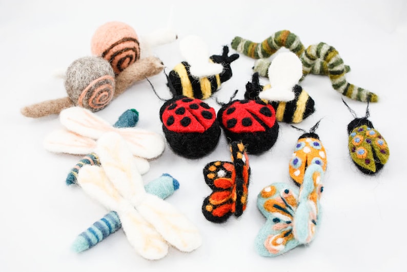 Pu&ograve; includere: Una collezione di figurine di animali in feltro, tra cui una lumaca, due coccinelle, due farfalle, due api, un bruco e due libellule. Le figurine sono tutte colorate in modo vivace e presentano dettagli intricati.