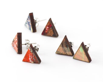 May include: A set of four triangular earrings made of wood with a painted design. The earrings are in shades of red, orange, brown, and green.