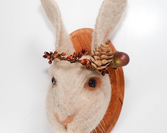 Retrato de conejo de fieltro con corona de piñas