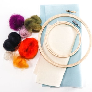 May include: A needle felting kit with a wooden embroidery hoop, two pieces of felt, and a variety of colored wool fibers.
