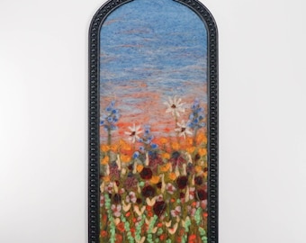 Paisaje pintado con lana fieltrada con aguja, arte textil, maleza y flores silvestres al atardecer.