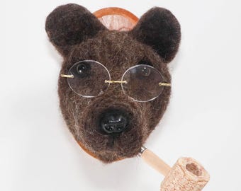 Retrato de oso hecho con fieltro de aguja, con pipa de mazorca de maíz y gafas.