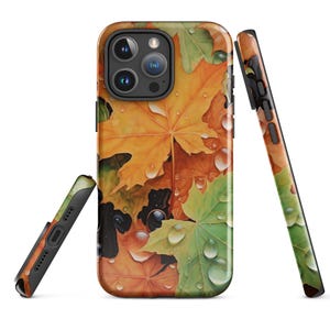 May include: A phone case with a colorful autumn leaf design. The case features a variety of fall leaves in shades of orange, yellow, green, and brown, with water droplets on the leaves. The case is designed for an iPhone.