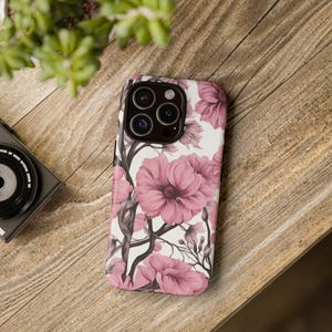 May include: A pink floral phone case with a white background. The case has a camera cutout with three lenses.