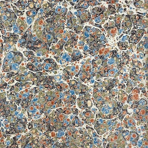 May include: A white ceramic mug with a black handle and the text "But First, Coffee" in a bold, black font. The mug is set against a blurred background, suggesting a cozy setting.