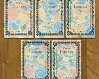 May include: Five rectangular cards with marbled patterns in pastel colors, framed with a decorative black border. Each card has the text "From the LIBRARY of" in a classic font, suggesting a library theme.